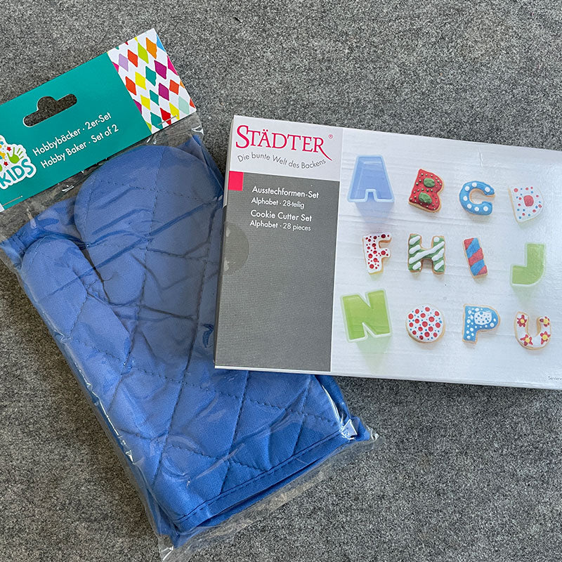 Ausstecherformen-Set Alphabet und das Kinderschürzen und -handschuh Set in der Farbe blau, beide Artikel von der Firma Städter.