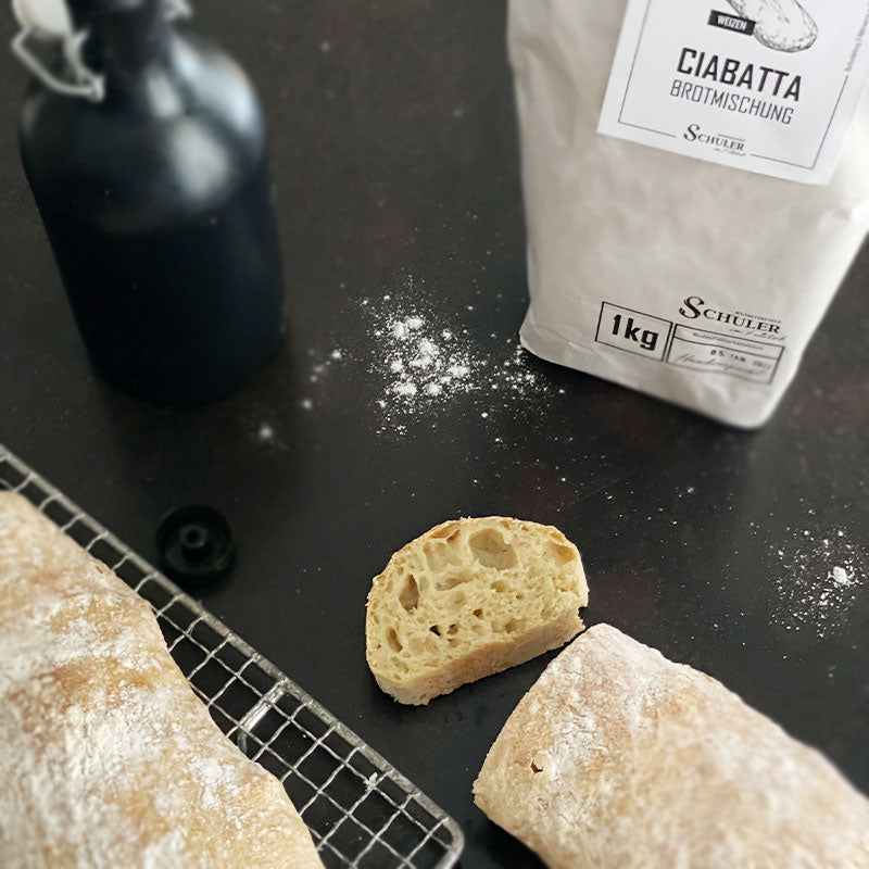 Ciabatta aufgeschnitten mit einer schwarzen Flasche Olivenöl und der Brotmischung Ciabatta
