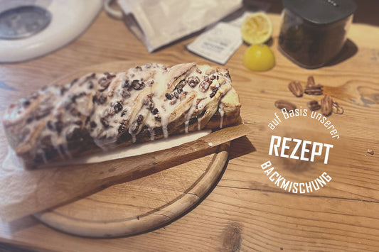 gezwirbelter Nusszopf mit Zuckerguss auf uriger Holzplatte