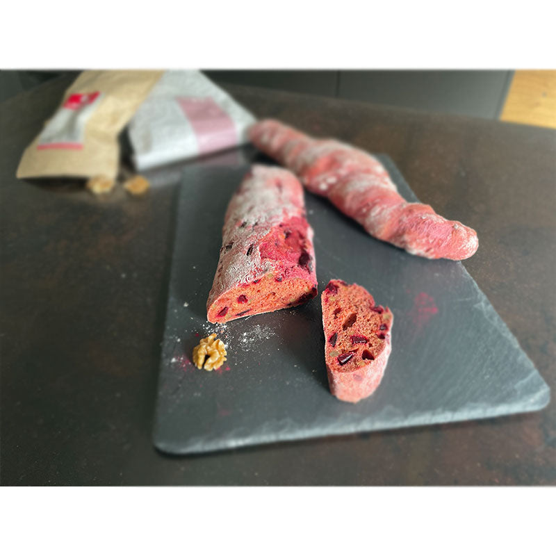 Ein rötliches Rote Bete Walnuss Baguette auf einer Schiefertafel 