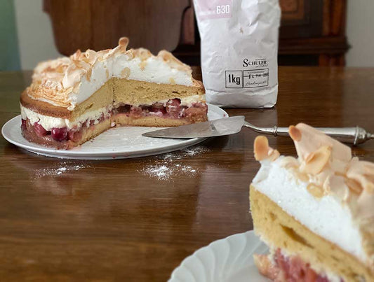 Angeschnittene Stachelbeer Torte auf antiquem Holztisch