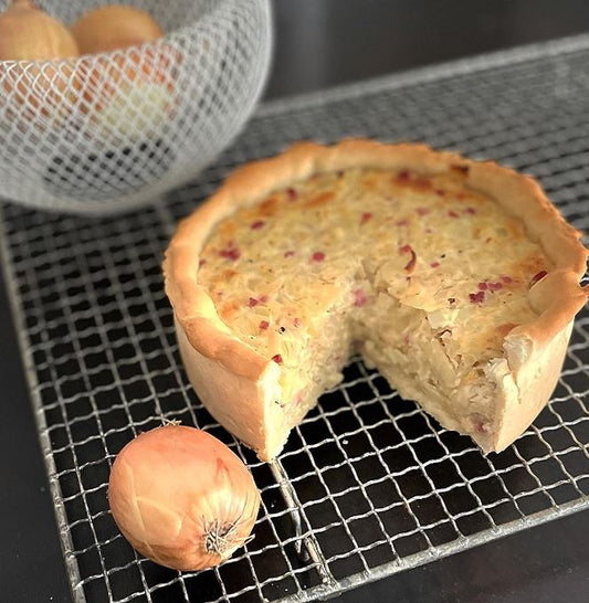 Angeschnittener Schwäbischer Zwiebelkuchen mit Speckwürfeln auf Backgitter