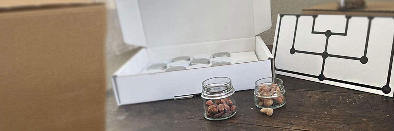 Die Snack Box Mühlenspiel geöffnet mit Glässchen voller Nüsse auf einem alten Holztisch