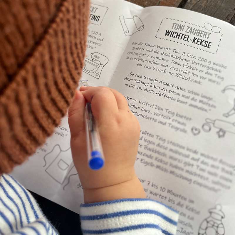 Kind beim Ausmalen  des Backhefts 2 Wichtel der Traditionsmühle Schuler