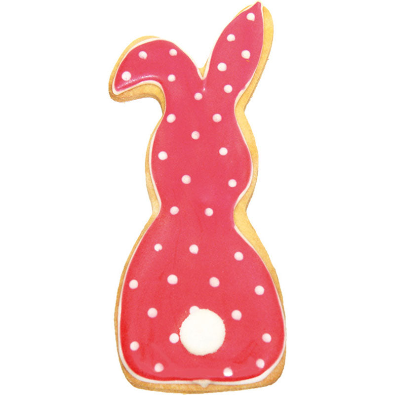 Fertiger Keks mit Verzierung, Hase mit Schlappohr, rote Glasur mit weißen Punkten und Puschelschwanz.