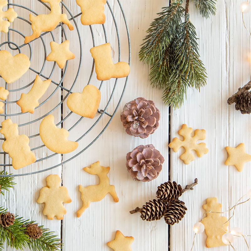 Keksausstecherbrett in Weiß von Städter, mit 27 Plätzchen und neun verschiedenen Motiven, je drei Ausstecher. Auf dem Bild ist ein Serviervorschlag abgebildet, wie die Plätzchen fertig aussehen können, die Verzierung fehlt noch.