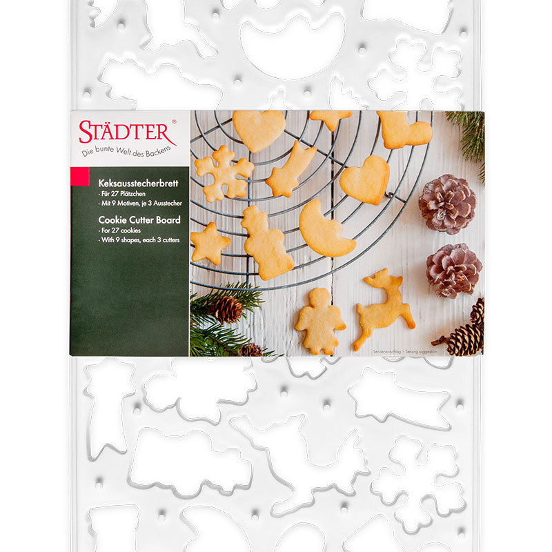 Keksausstecherbrett in Weiß von Städter, mit 27 Plätzchen und neun verschiedenen Motiven, je drei Ausstecher. Auf der Verpackung ist ein Serviervorschlag abgebildet, wie die Plätzchen fertig aussehen können, die Verzierung fehlt noch.