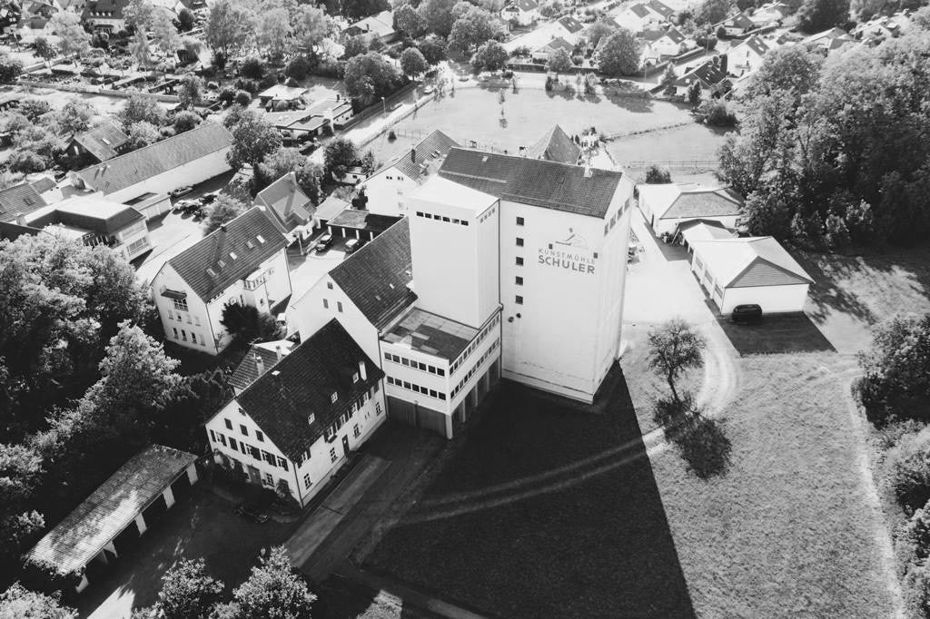 Die historische Mühle, Produktion, Mehlsilos und Mühlenladen der Kunstmühle Schuler von oben in schwarz weiß in Süssen