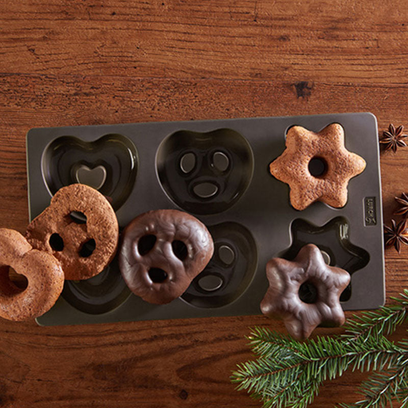 Lebkuchen Flexiform von Lurch aus 100% Premium Silikon, in der Farbe braun. Jeweils zwei Lebkuchen in Herz- Brezel- oder Sternform finden in der Form platz, Beispiele von fertigen Lebkuchen sind abgebildet, mit und ohne Schokoglasur.
